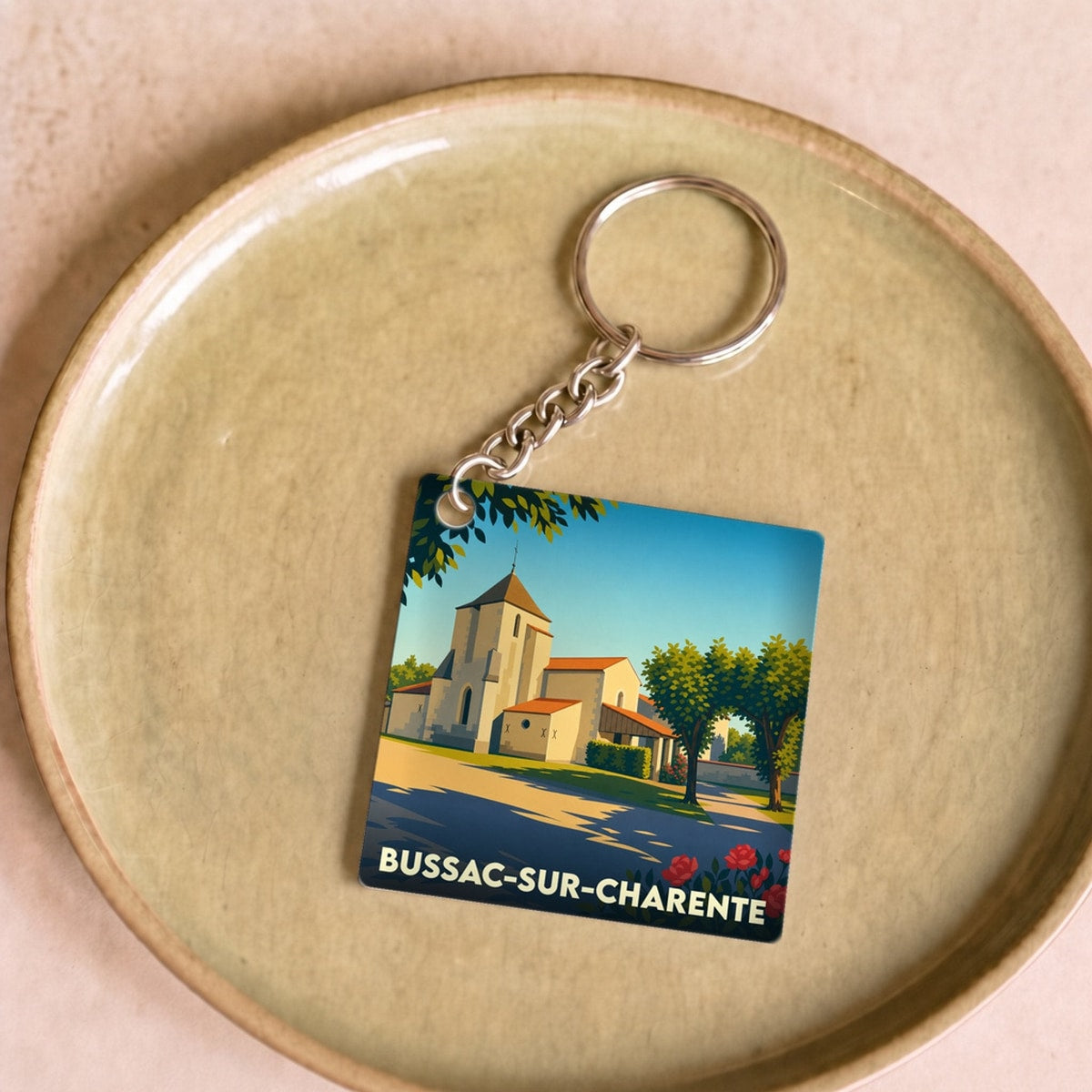 Porte-clés souvenir de la ville de Bussac-sur-Charente avec une illustration stylisée.