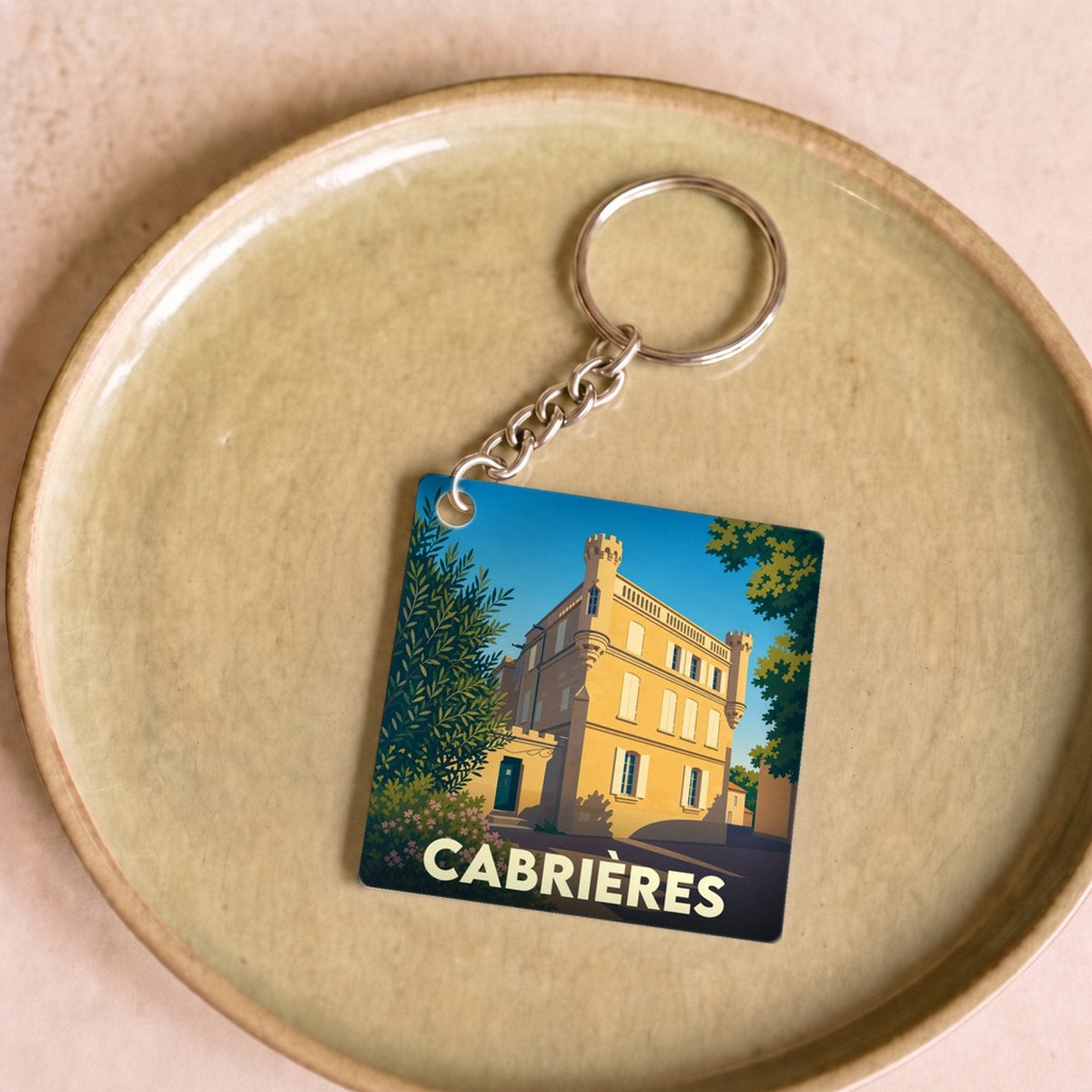 Porte-clés souvenir de la ville de Cabrières avec une illustration stylisée d'un château ensoleillé.