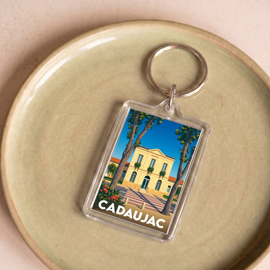 Porte-clés souvenir de la ville de Cadaujac avec une illustration stylisée.