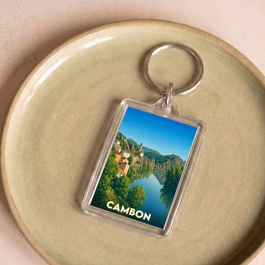 Porte-clés souvenir de la ville de Cambon avec une illustration stylisée d'un paysage fluvial.