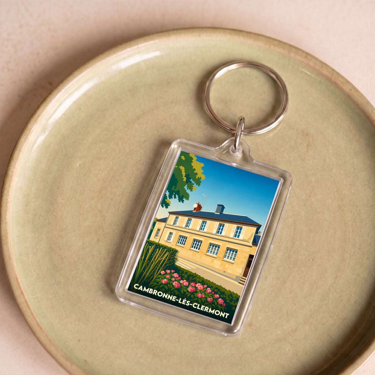 Porte-clés souvenir de la ville de Cambronne-lès-Clermont avec une illustration stylisée.