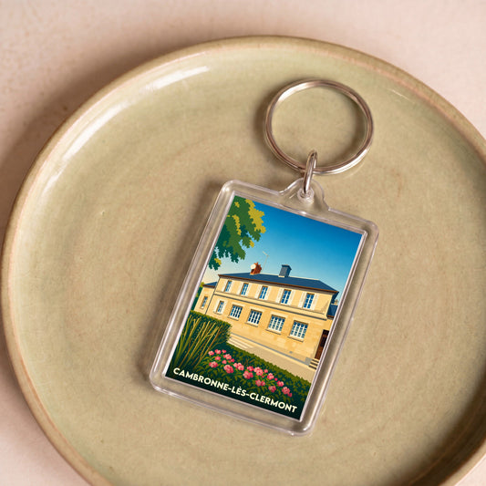 Porte-clés souvenir de la ville de Cambronne-lès-Clermont avec une illustration stylisée.
