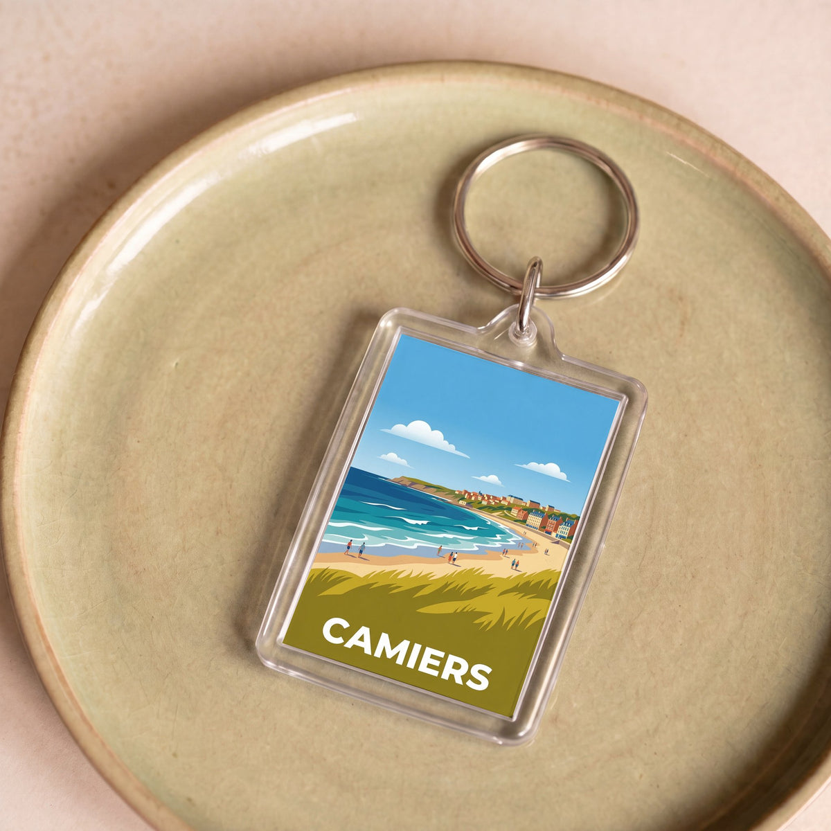 Porte-clés souvenir de la ville de Camiers avec une illustration de bord de mer stylisée.