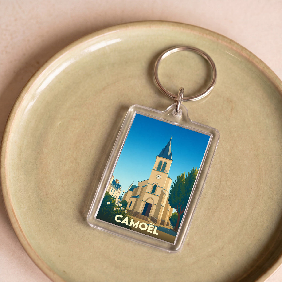 Porte-clés souvenir de la ville de Camoël avec une illustration stylisée de son église.