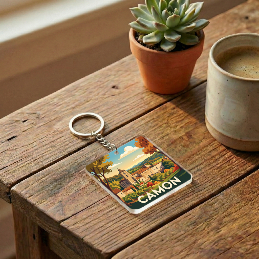 Porte-clés souvenir de la ville de Camon avec une illustration stylisée de son paysage.