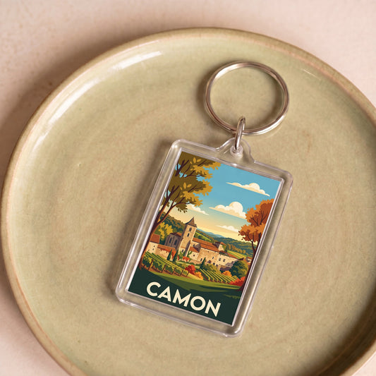 Porte-clés souvenir de la ville de Camon avec une illustration stylisée de son paysage.