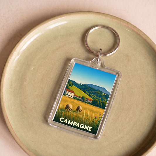 Porte-clés souvenir de la ville de Campagne avec une illustration stylisée d'un paysage rural.