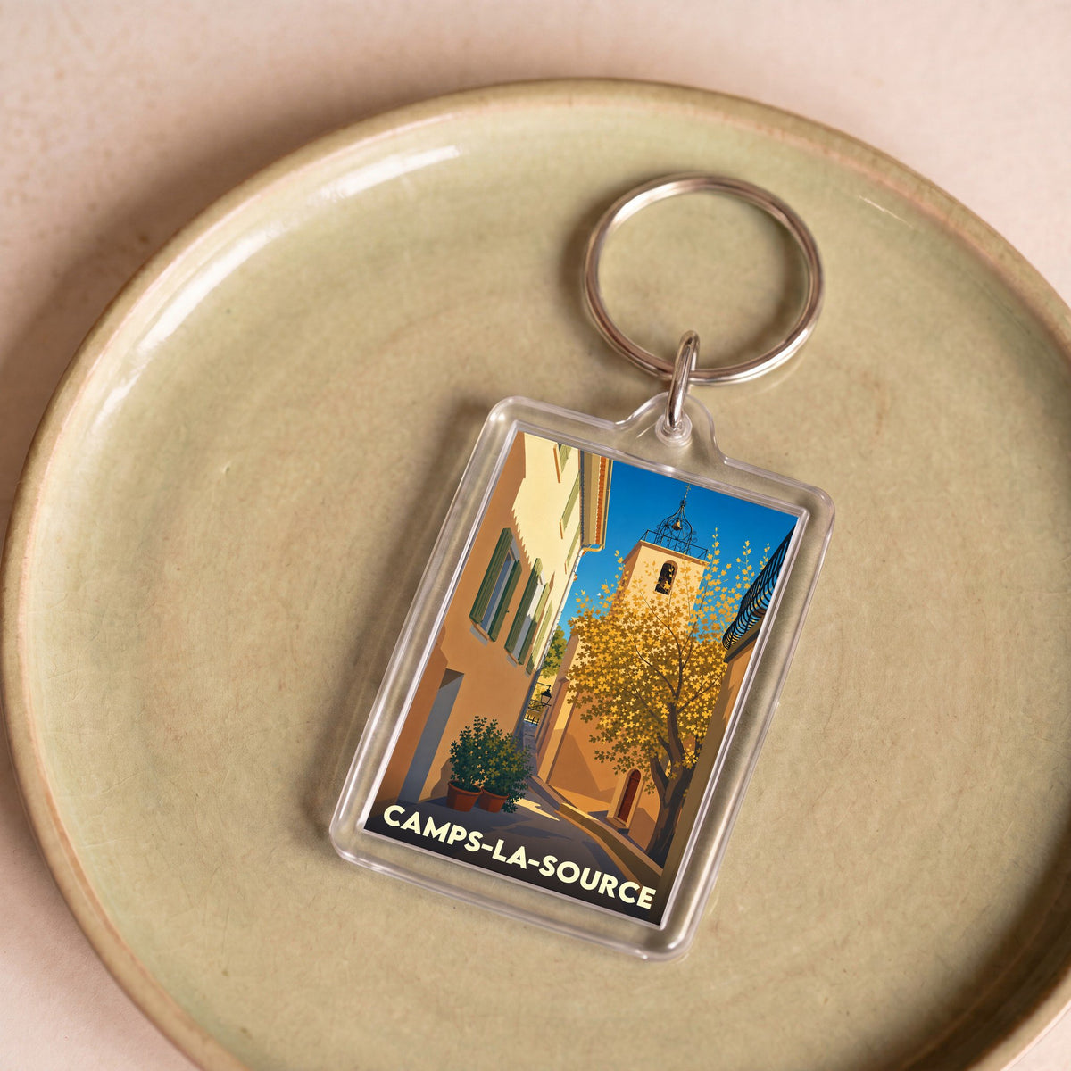 Porte-clés souvenir de la ville de Camps-la-Source avec une illustration stylisée d'une ruelle provençale.