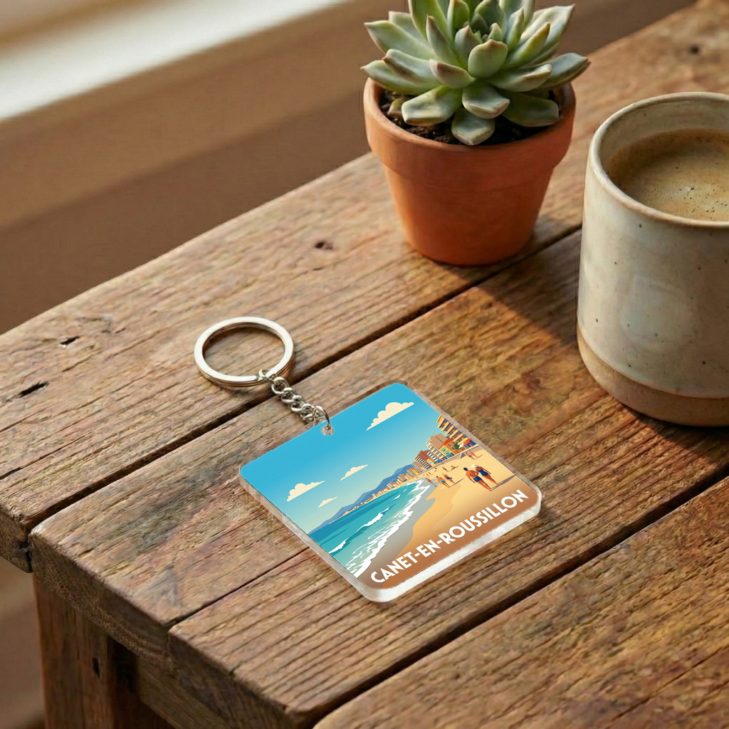 Porte-clés souvenir de la ville de Canet-en-Roussillon avec une illustration de plage stylisée.