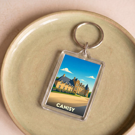Porte-clés souvenir de la ville de Canisy avec une illustration stylisée de son château.