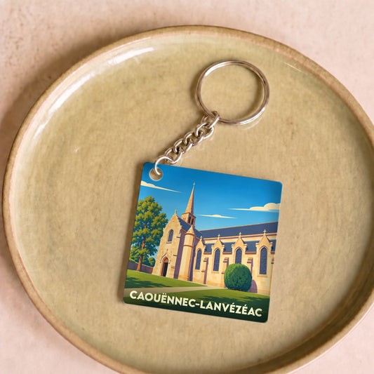 Porte-clés souvenir de la ville de Caouënnec-Lanvézéac avec une illustration stylisée d'une église.