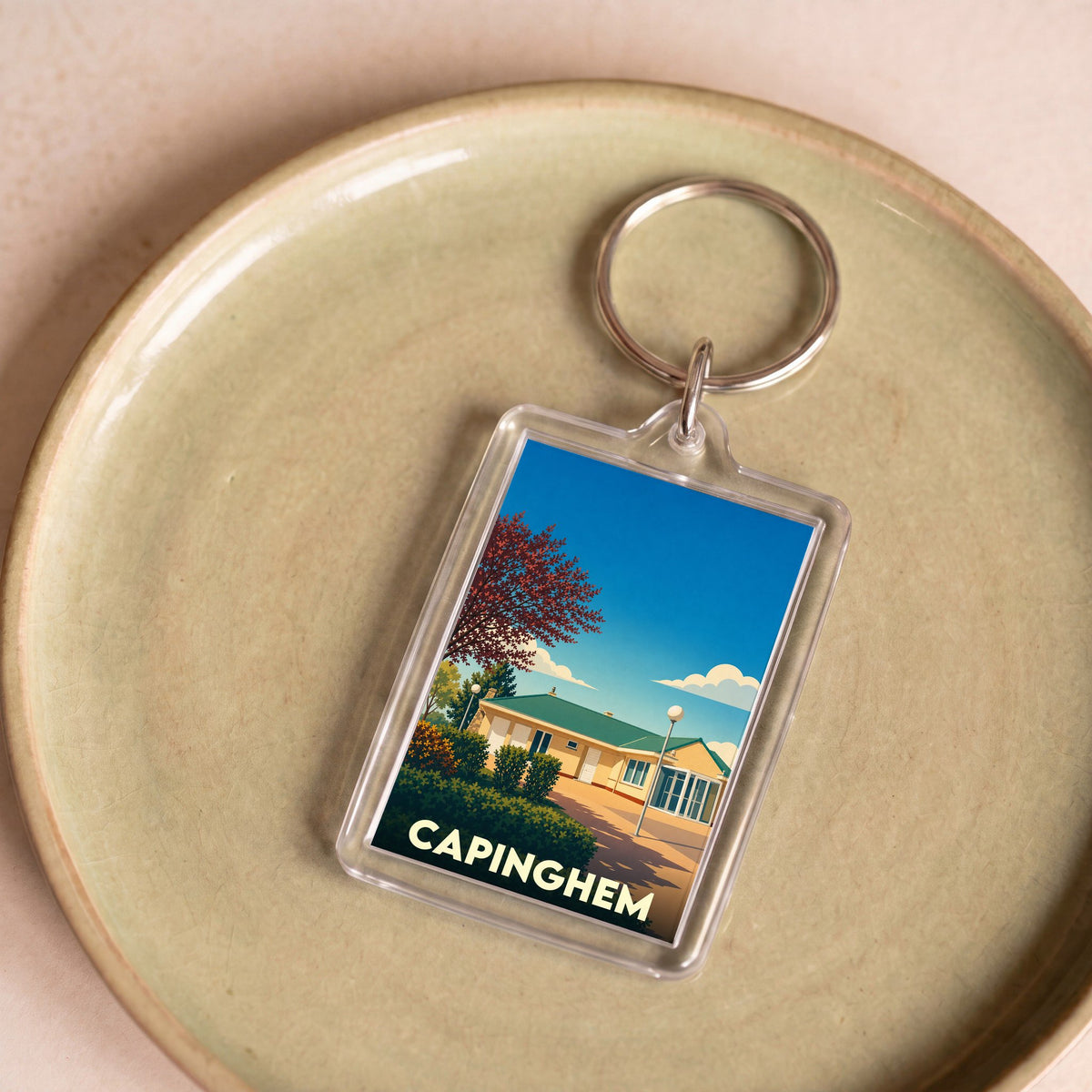 Porte-clés souvenir de la ville de Capinghem avec une illustration stylisée.