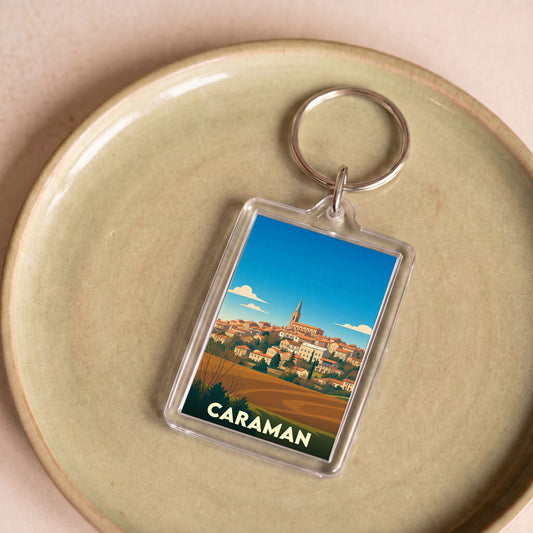 Porte-clés souvenir de la ville de Caraman avec une illustration stylisée.