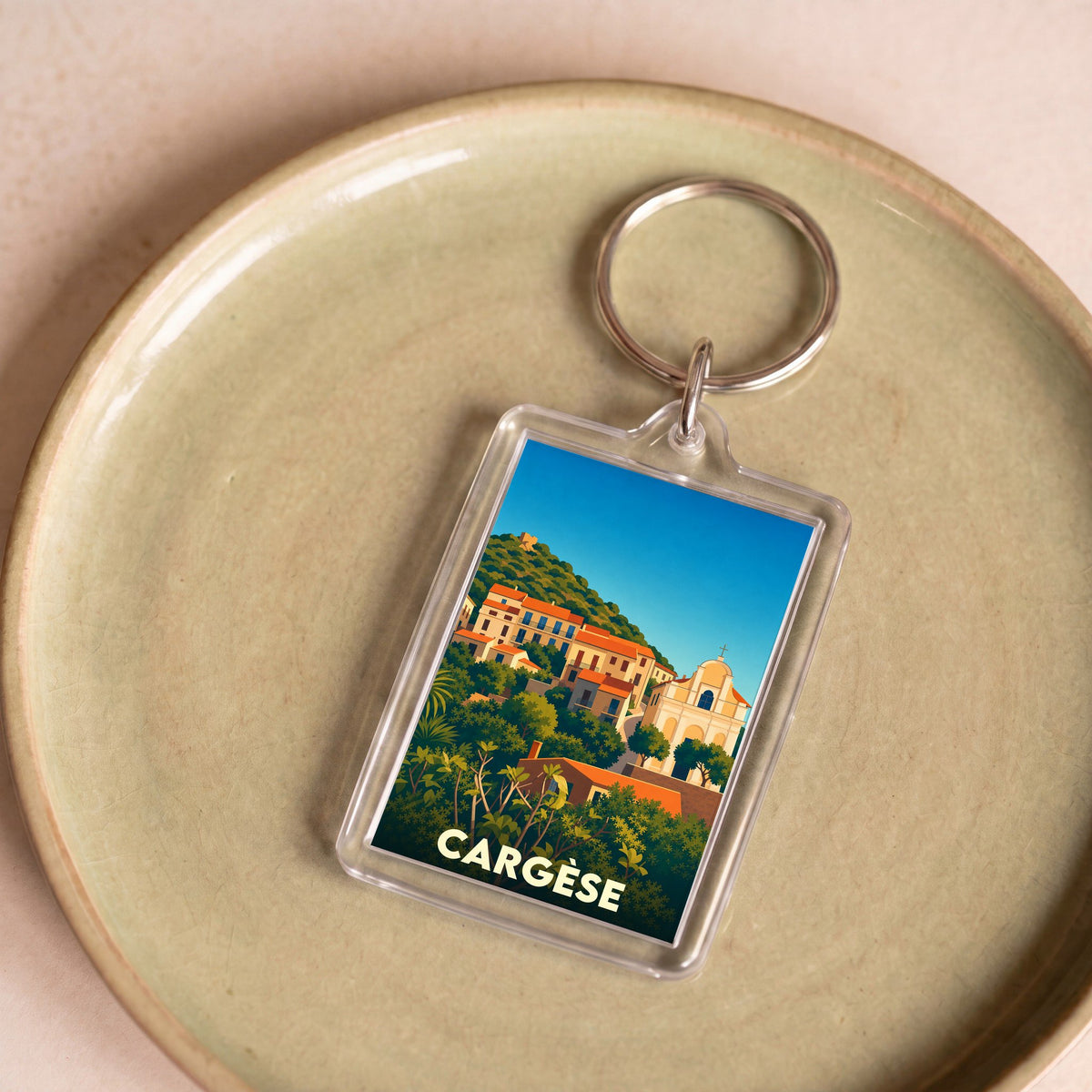 Porte-clés souvenir de la ville de Cargèse avec une illustration stylisée d'un village corse.