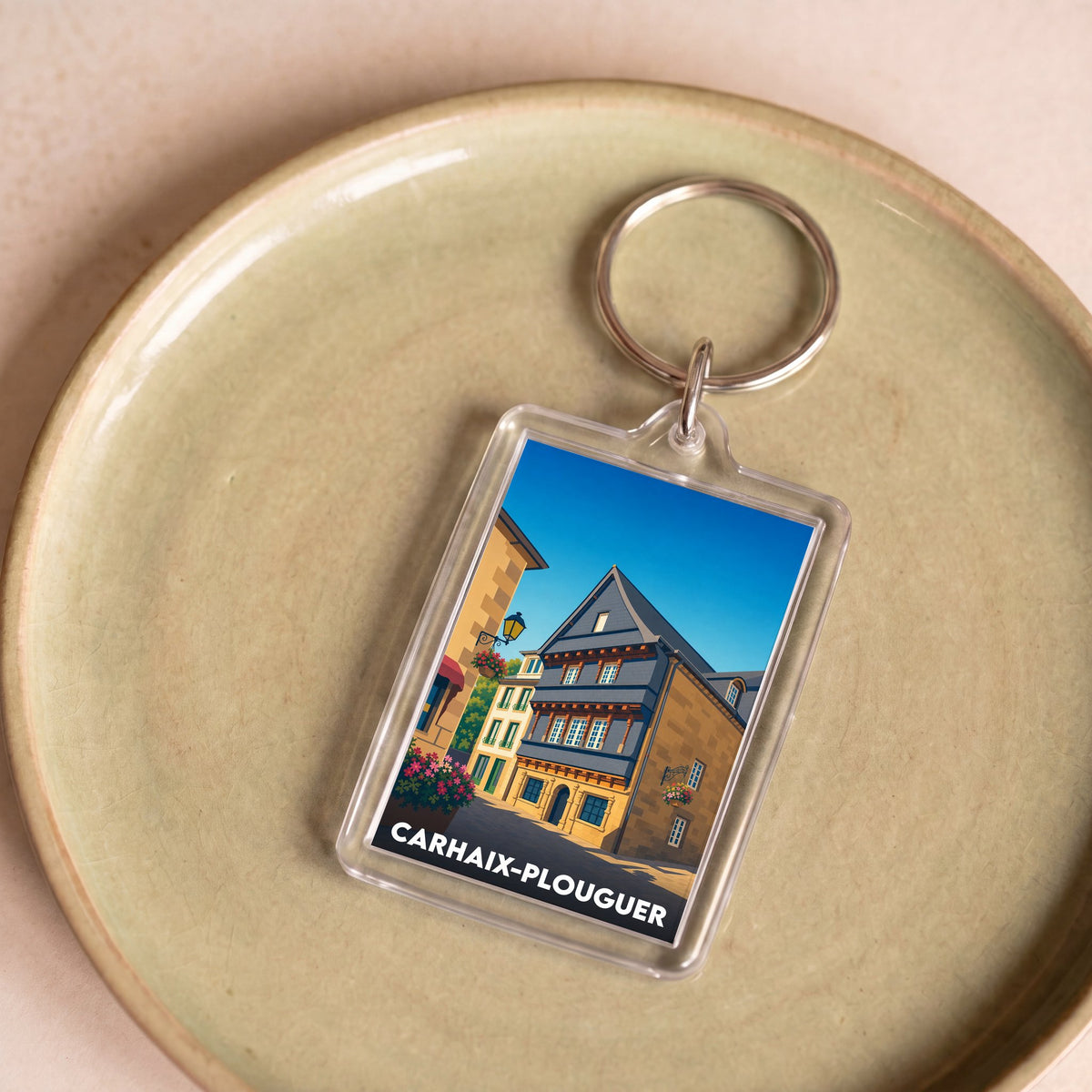 Porte-clés souvenir de la ville de Carhaix-Plouguer avec une illustration stylisée d'une maison ancienne.