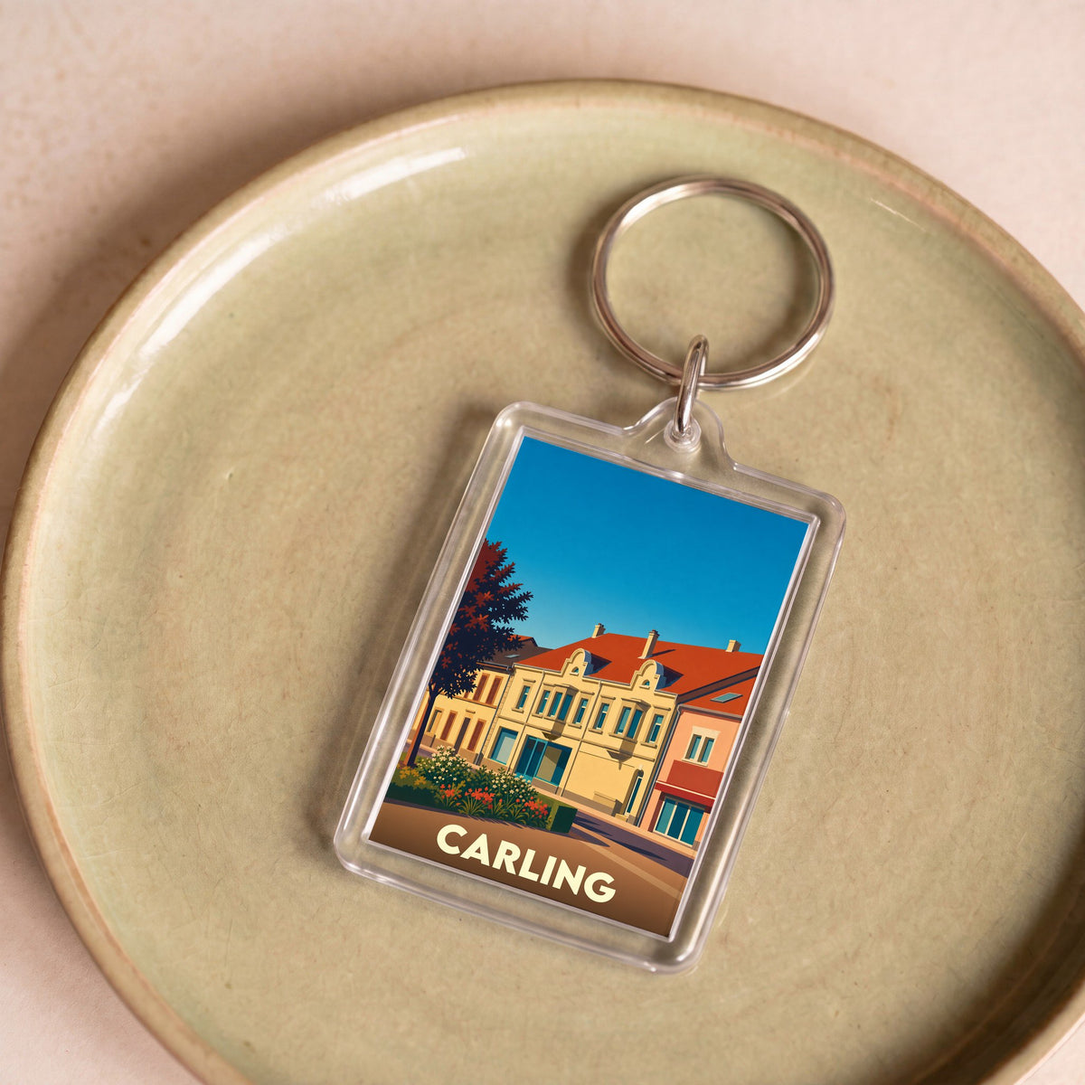 Porte-clés souvenir de la ville de Carling avec une illustration stylisée.