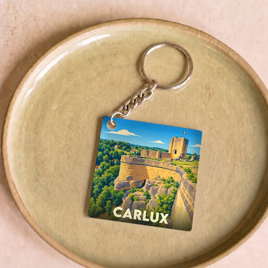 Porte-clés souvenir de la ville de Carlux avec une illustration stylisée de son château médiéval.