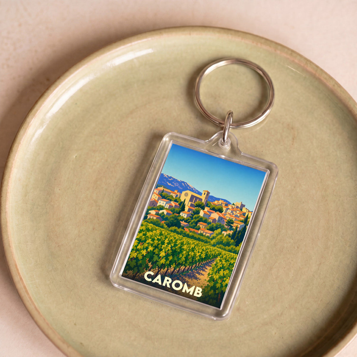 Porte-clés souvenir de la ville de Caromb avec une illustration stylisée.
