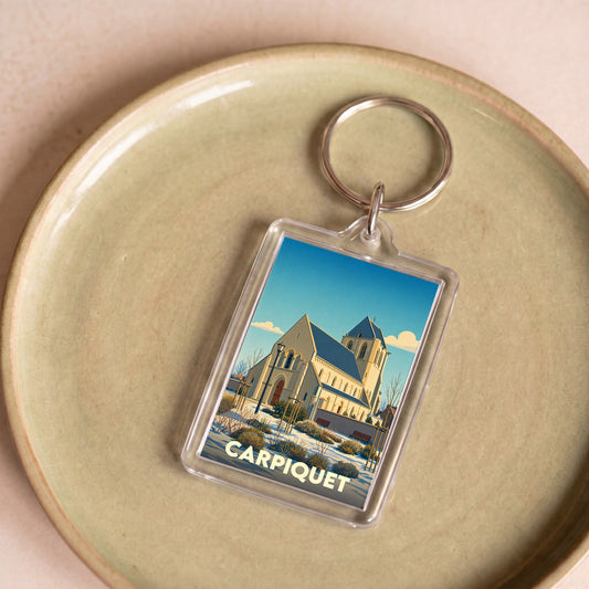Porte-clés souvenir de la ville de Carpiquet avec une illustration stylisée de son église.