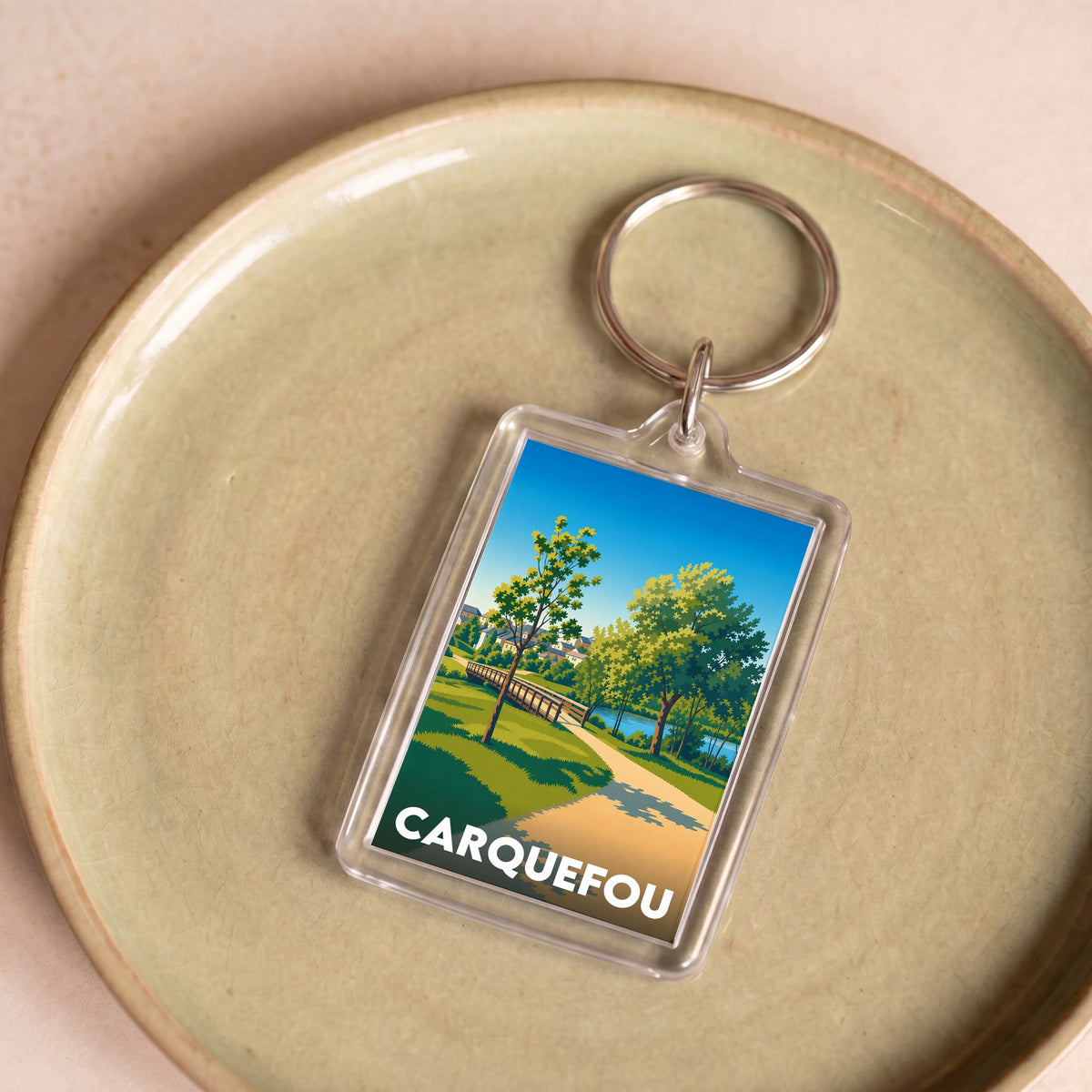 Porte-clés souvenir de la ville de Carquefou avec une illustration stylisée d'un parc.