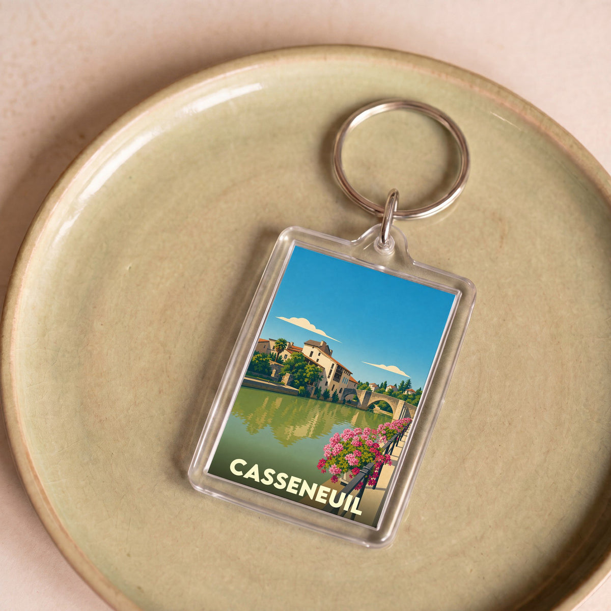 Porte-clés souvenir de la ville de Casseneuil avec une illustration stylisée.