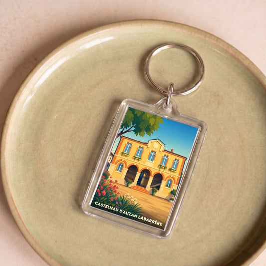 Porte-clés souvenir de la commune de Castelnau d'Auzan Labarrère avec une illustration stylisée.