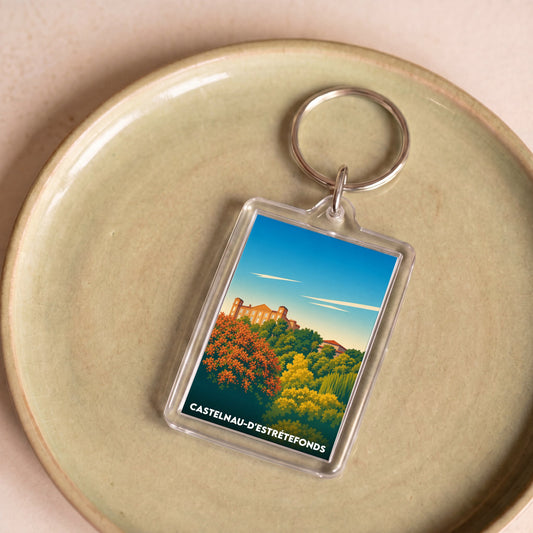 Porte-clés souvenir de la ville de Castelnau-d'Estrétefonds avec une illustration stylisée.