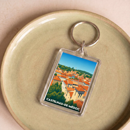 Porte-clés souvenir de la ville de Castelnau-de-Médoc avec une illustration stylisée.