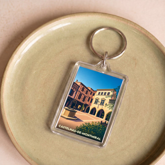 Porte-clés souvenir de la ville de Castelnau-de-Montmiral avec une illustration stylisée de sa place centrale.
