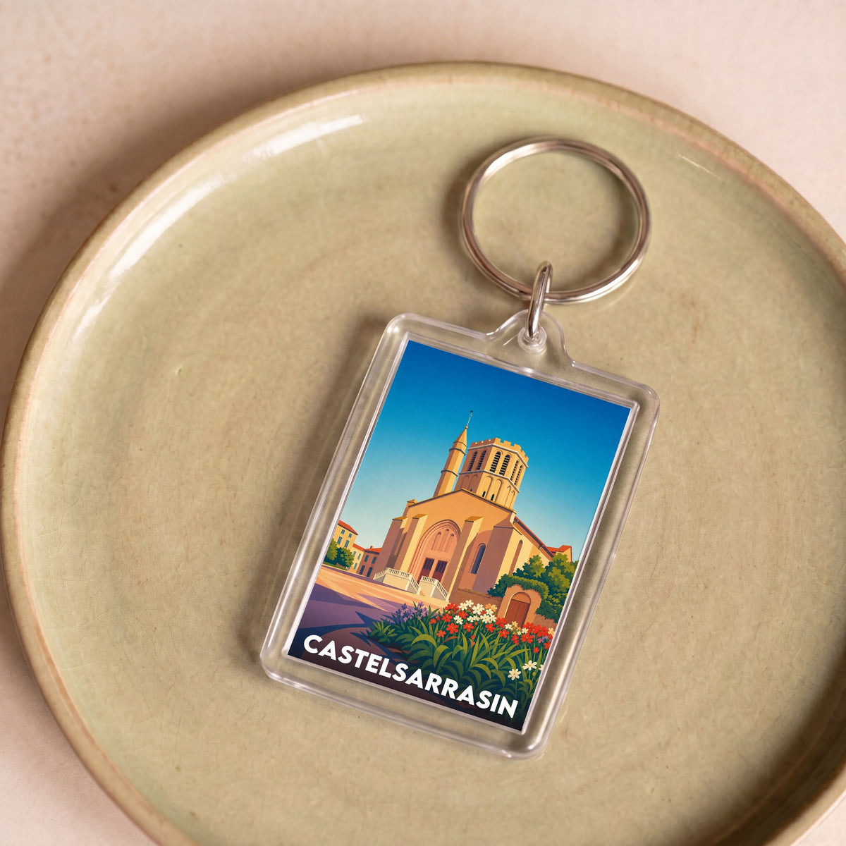 Porte-clés souvenir de la ville de Castelsarrasin avec une illustration graphique stylisée.