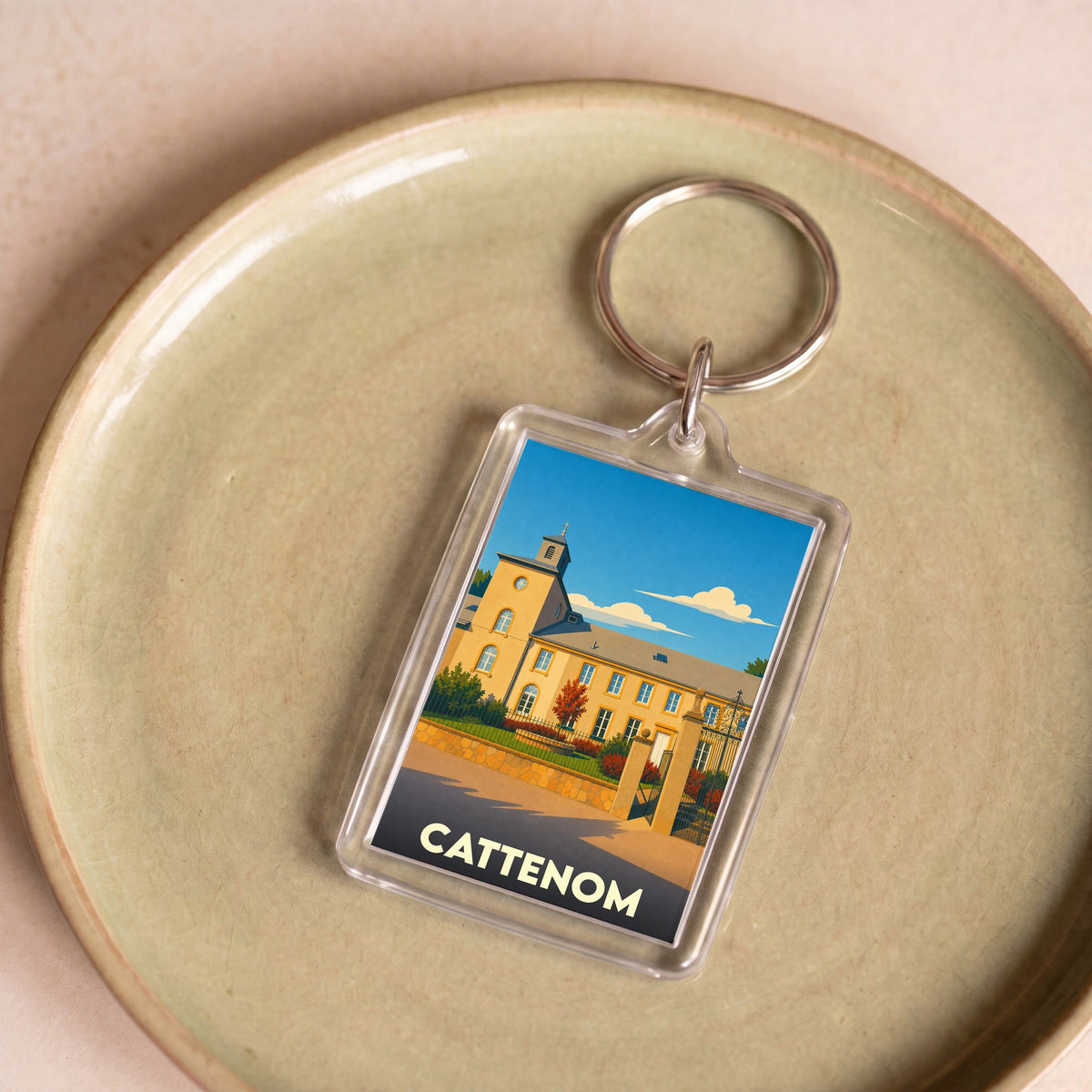 Porte-clés souvenir de la ville de Cattenom avec une illustration stylisée.