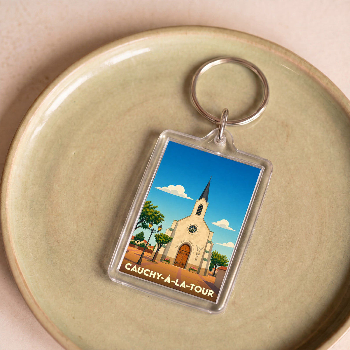 Porte-clés souvenir de la ville de Cauchy-à-la-Tour avec une illustration stylisée de son église.