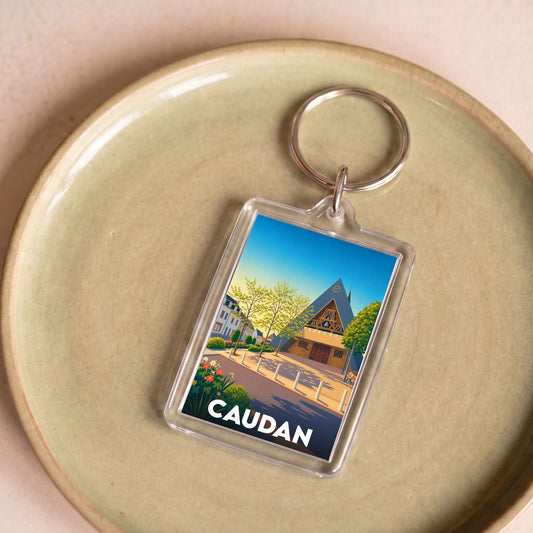 Porte-clés souvenir de la ville de Caudan avec une illustration stylisée.
