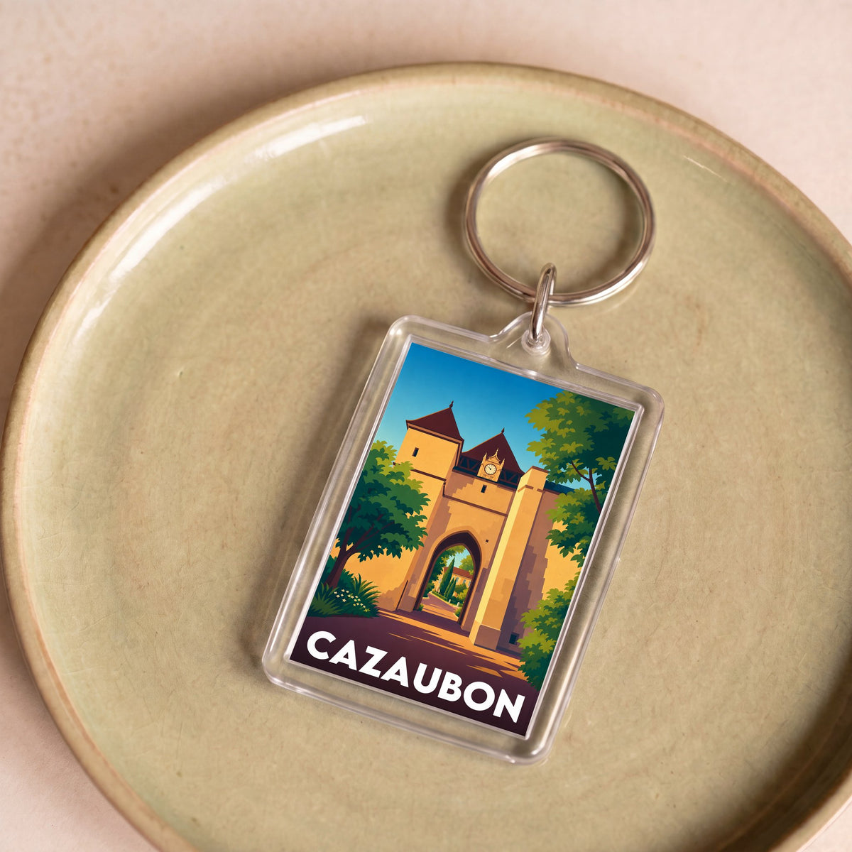Porte-clés souvenir de la ville de Cazaubon avec une illustration stylisée.