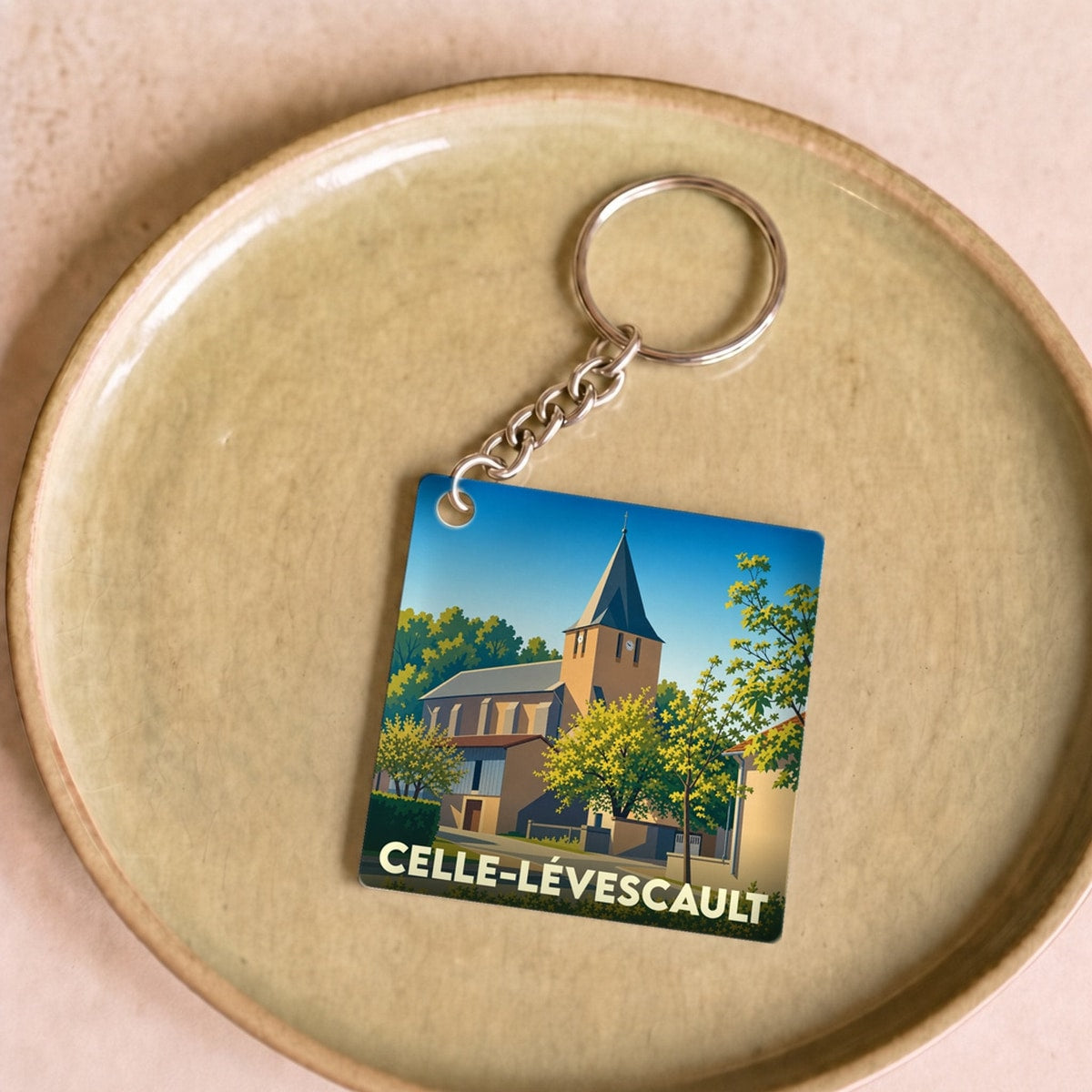 Porte-clés souvenir de la ville de Celle-Lévescault avec une illustration stylisée de son église.