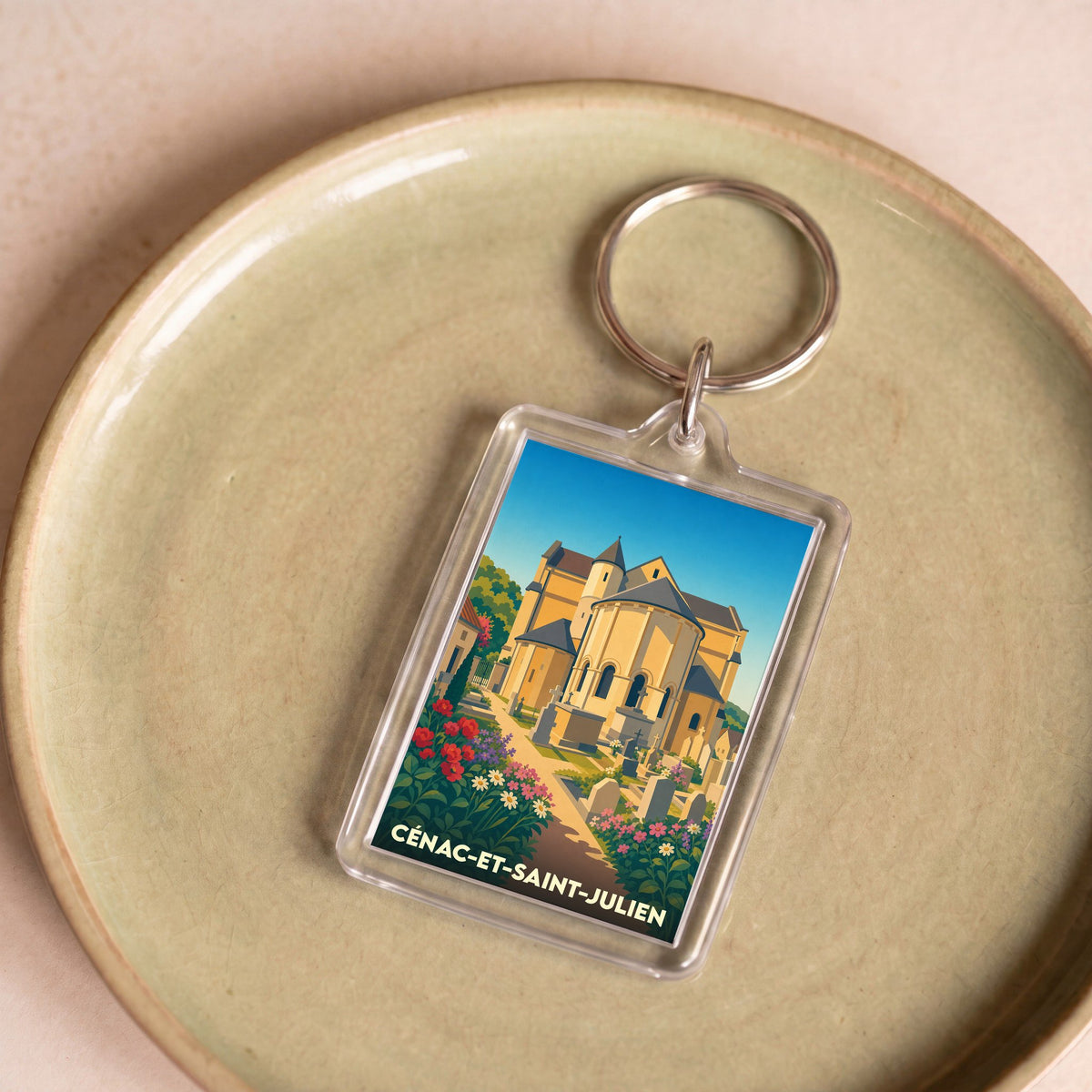Porte-clés souvenir de la ville de Cénac-et-Saint-Julien avec une illustration stylisée de son église et de ses fleurs.