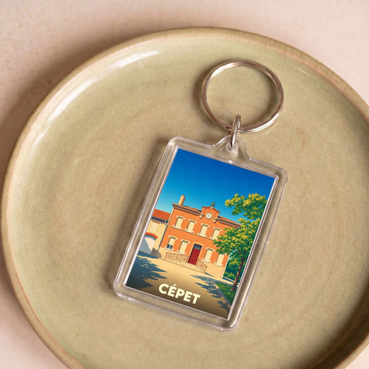 Porte-clés souvenir de la ville de Cépet avec une illustration stylisée de sa mairie.