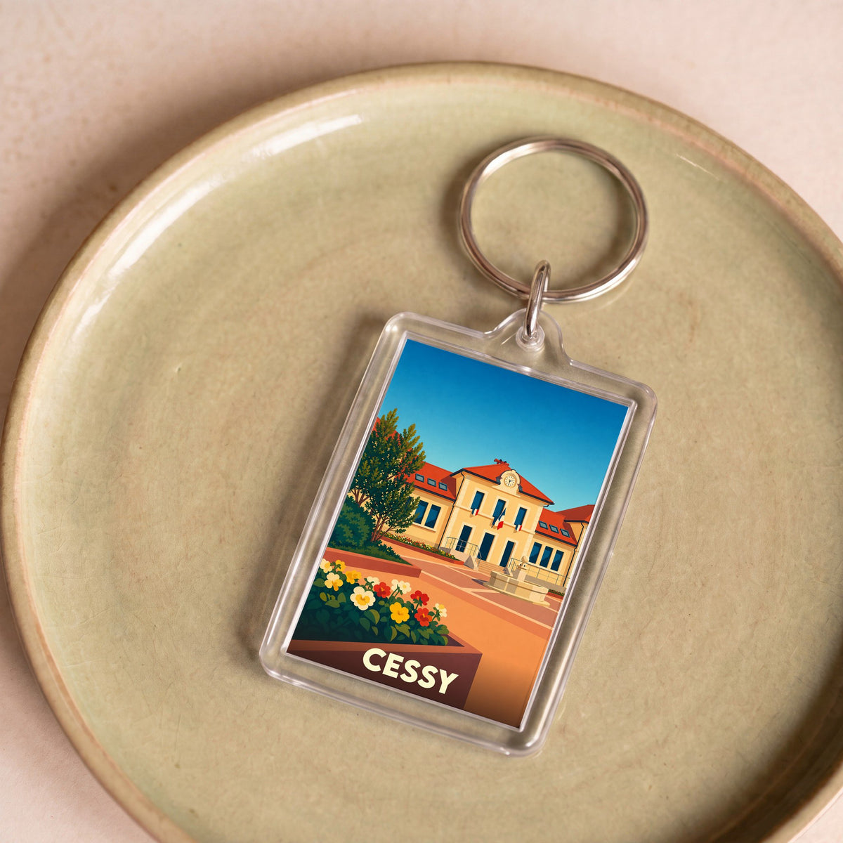 Porte-clés souvenir de la ville de Cessy avec une illustration stylisée.