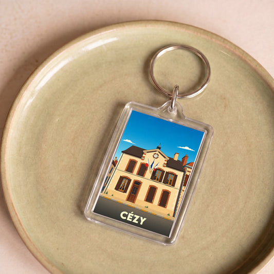 Porte-clés souvenir de la ville de Cézy avec une illustration stylisée de sa mairie.
