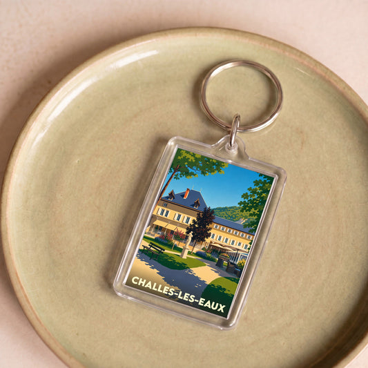Porte-clés souvenir de la ville de Challes-les-Eaux avec une illustration stylisée d'un bâtiment historique et de ses jardins.