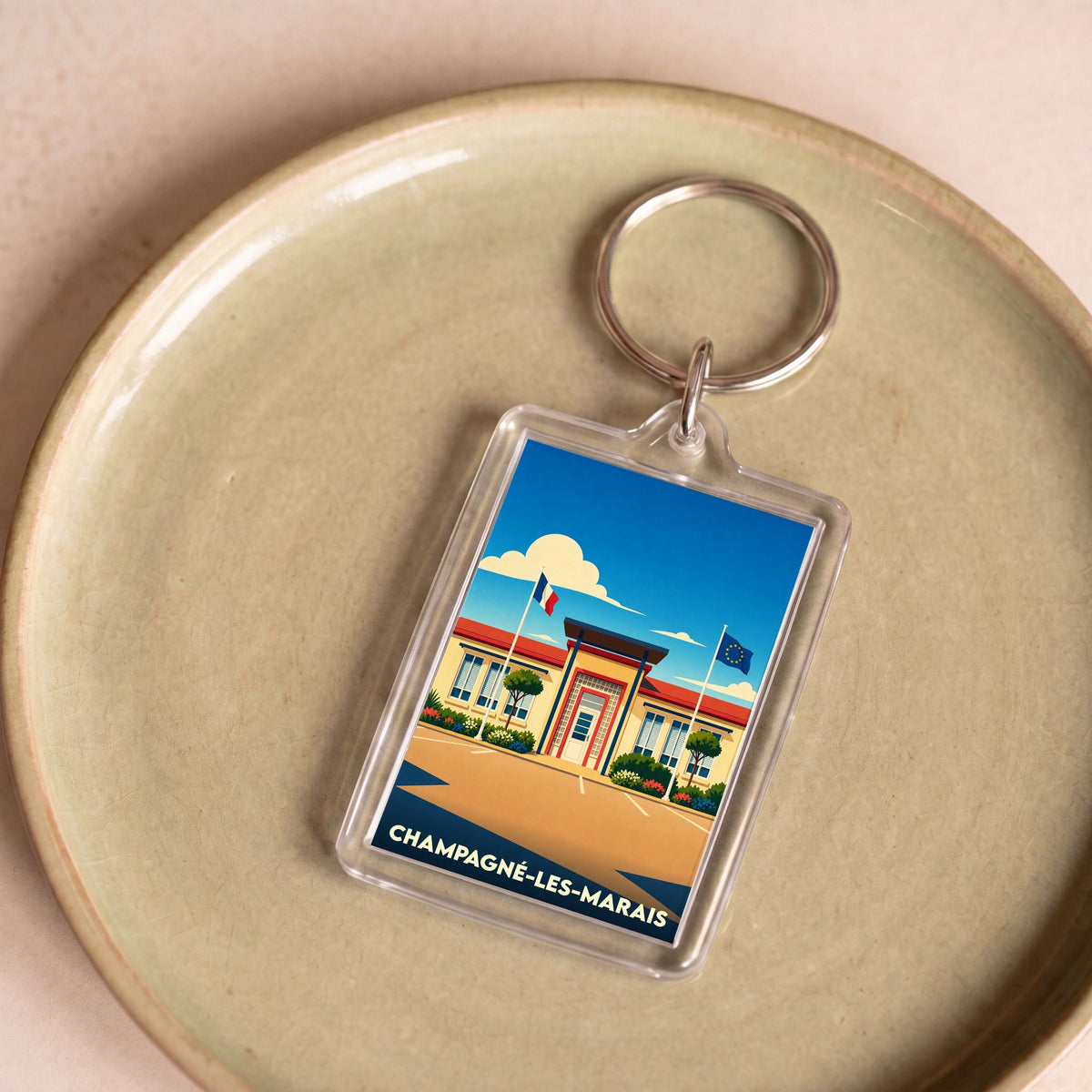 Porte-clés souvenir de la ville de Champagné-les-Marais avec une illustration stylisée de sa mairie.