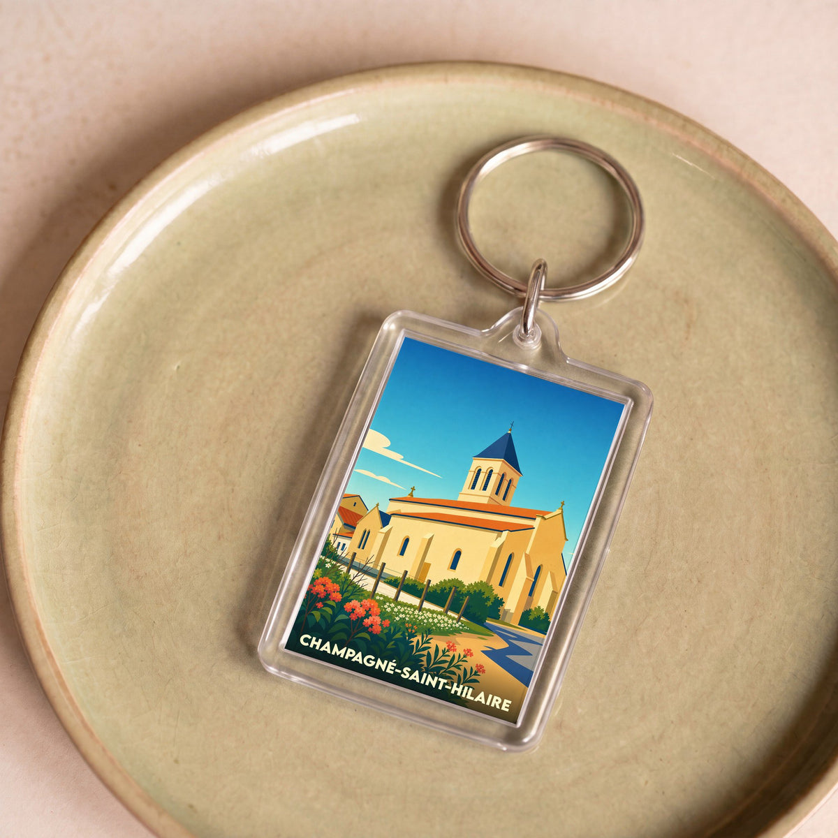 Porte-clés souvenir de la ville de Champagné-Saint-Hilaire avec une illustration stylisée de son église.