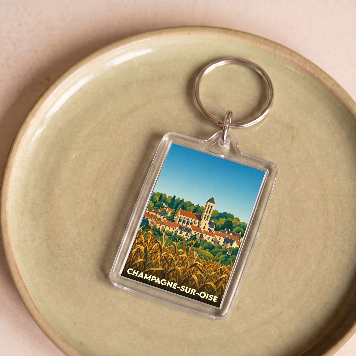 Porte-clés souvenir de la ville de Champagne-sur-Oise avec une illustration stylisée.