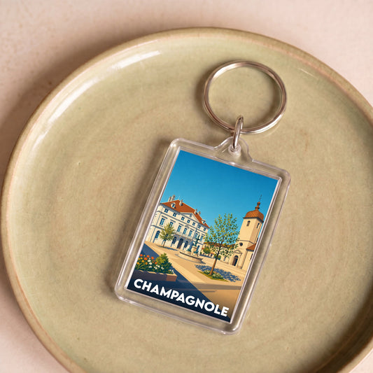 Porte-clés souvenir de la ville de Champagnole avec une illustration stylisée de son architecture.