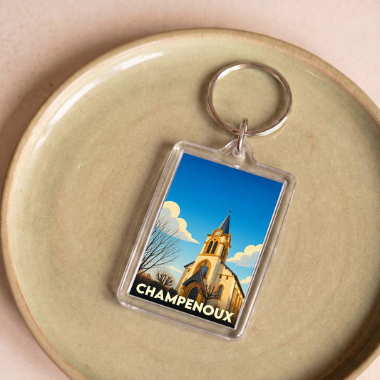 Porte-clés souvenir de la ville de Champenoux avec une illustration stylisée d'église.