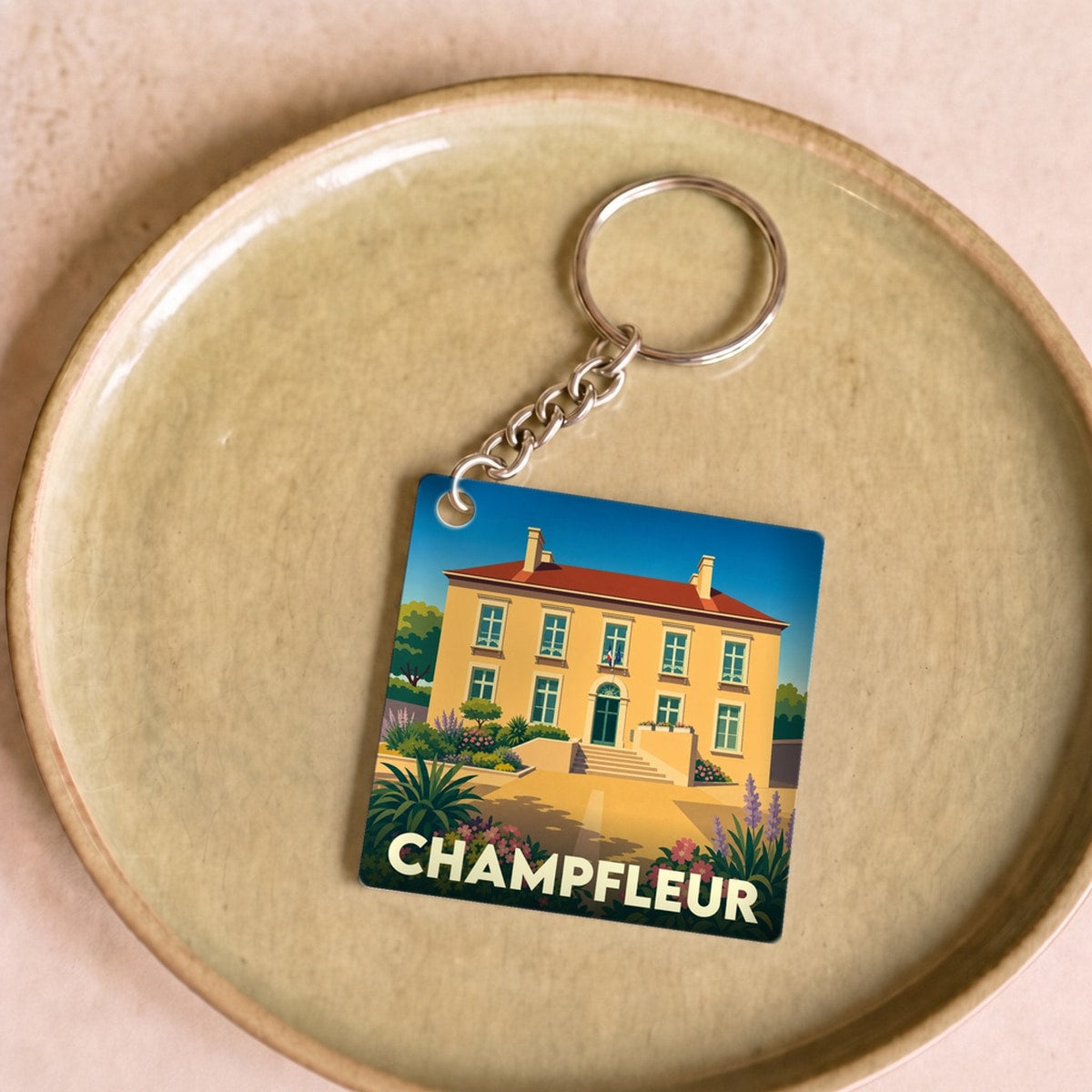 Porte-clés souvenir de la ville de Champfleur avec une illustration stylisée de sa mairie.