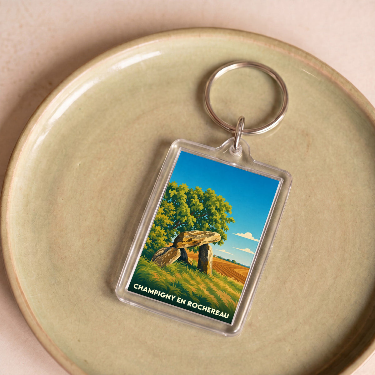 Porte-clés souvenir de la ville de Champigny en Rochereau avec une illustration stylisée d'un dolmen.