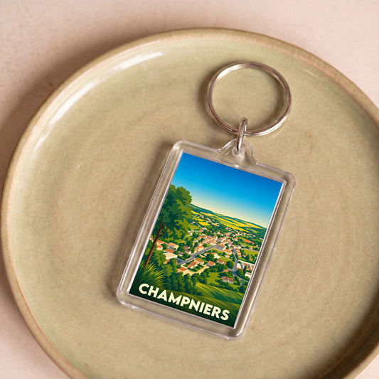 Porte-clés souvenir de la ville de Champniers avec une illustration stylisée d'un paysage de campagne.