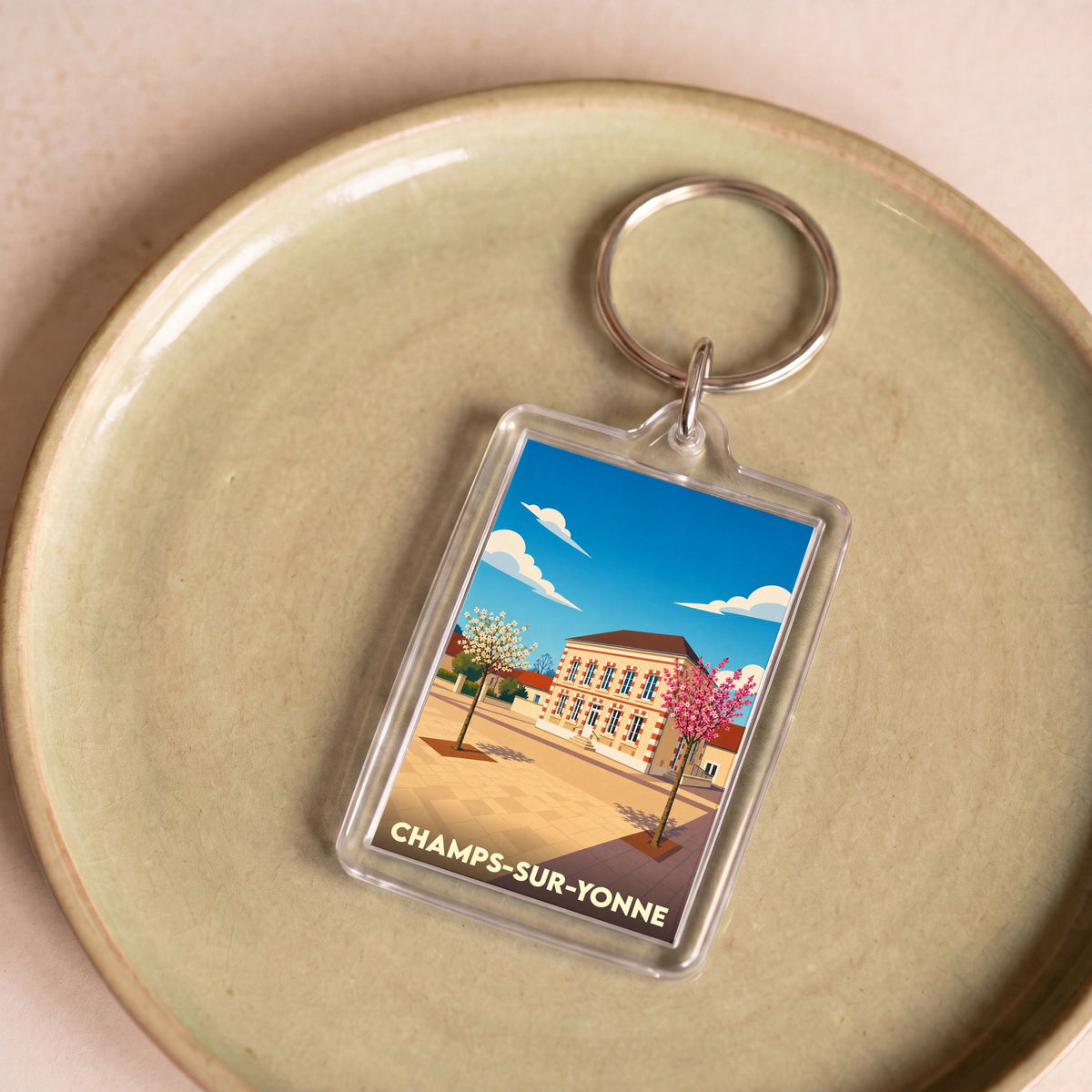 Porte-clés souvenir de la ville de Champs-sur-Yonne avec une illustration stylisée de sa mairie.