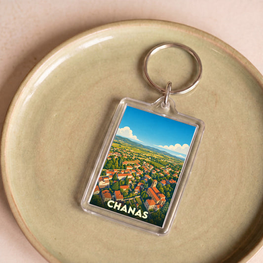 Porte-clés souvenir de la ville de Chanas avec une illustration stylisée d'un paysage urbain et rural.
